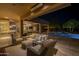 Comfortable covered patio with wicker furniture, outdoor kitchen, dining area, and pool in this backyard space at 8248 E Arroyo Hondo Rd, Scottsdale, AZ 85266