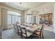 Bright dining room with a large window, elegant curtains, a rustic table, and easy access to the bar at 8248 E Arroyo Hondo Rd, Scottsdale, AZ 85266