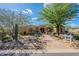 Beautiful home showcasing attractive desert landscaping, a stone walkway, and mature trees at 8248 E Arroyo Hondo Rd, Scottsdale, AZ 85266