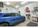 Organized garage featuring a clean floor, shelving and a stylish blue car at 8248 E Arroyo Hondo Rd, Scottsdale, AZ 85266