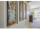 Hallway with decorative art leading to a bright area with outdoor views at 8248 E Arroyo Hondo Rd, Scottsdale, AZ 85266