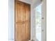 Hallway with wooden pantry cabinet and view of sunlit exterior through glass door at 8248 E Arroyo Hondo Rd, Scottsdale, AZ 85266