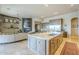 Open-concept kitchen featuring a large island, stainless appliances, fireplace, and comfortable living space at 8248 E Arroyo Hondo Rd, Scottsdale, AZ 85266