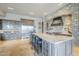 Elegant kitchen boasting a stone accent wall, a large center island with seating, and stainless steel appliances at 8248 E Arroyo Hondo Rd, Scottsdale, AZ 85266