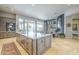 Open kitchen with an oversized island, wooden cabinets, and stainless appliances leading to a living space at 8248 E Arroyo Hondo Rd, Scottsdale, AZ 85266