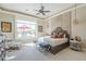 Sunlit bedroom boasts a decorative headboard, ceiling fan, and expansive window with pool view at 8248 E Arroyo Hondo Rd, Scottsdale, AZ 85266