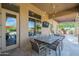 A covered patio featuring an outdoor dining area with desert views and comfortable seating at 8248 E Arroyo Hondo Rd, Scottsdale, AZ 85266