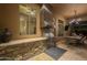 Outdoor kitchen and dining area with stainless steel appliances, stone accents, and an adjacent exterior dining table at 8248 E Arroyo Hondo Rd, Scottsdale, AZ 85266