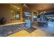Well-equipped outdoor kitchen area with stainless steel appliances, stone countertop, dining table, and covered patio at 8248 E Arroyo Hondo Rd, Scottsdale, AZ 85266