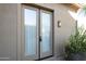 Patio featuring large glass doors, exterior light fixture, and lush potted greenery at 8248 E Arroyo Hondo Rd, Scottsdale, AZ 85266