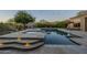 Outdoor swimming pool with spa, stone decking, illuminated stairs, and views of the lush backyard landscaping at 8248 E Arroyo Hondo Rd, Scottsdale, AZ 85266