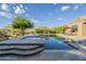 An in-ground pool with baja shelf, a sun-soaked patio and a well-manicured desert landscape at 8248 E Arroyo Hondo Rd, Scottsdale, AZ 85266