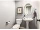 Charming powder room with pedestal sink, oval mirror, and an elegant light gray color scheme at 850 W Folley St, Chandler, AZ 85225