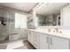 Bathroom featuring a double vanity, tiled shower, and ample lighting at 850 W Folley St, Chandler, AZ 85225