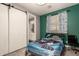 This bedroom has grey wood floors, a green accent wall, barn closet door and ensuite bathroom at 850 W Folley St, Chandler, AZ 85225