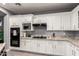 Kitchen with white cabinetry, granite countertops, and modern black appliances at 850 W Folley St, Chandler, AZ 85225