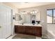 Bathroom showcasing a double vanity with a big mirror, neutral tile floors, and white walls at 8555 W Purdue Ave, Peoria, AZ 85345
