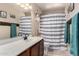 Neutral bathroom featuring vanity with sink, decorated with a patterned shower curtain at 8555 W Purdue Ave, Peoria, AZ 85345