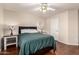 This bedroom features wood floors, a ceiling fan, bedside tables with lamps, and one window at 8555 W Purdue Ave, Peoria, AZ 85345