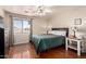 This bedroom features wood floors, neutral walls, a ceiling fan, and a window with natural light at 8555 W Purdue Ave, Peoria, AZ 85345