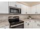 A modern kitchen featuring stainless steel appliances, granite countertops, and white cabinets at 8555 W Purdue Ave, Peoria, AZ 85345