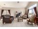 Bright living room featuring comfortable seating, neutral decor, and a large window with backyard views at 8555 W Purdue Ave, Peoria, AZ 85345