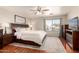 Serene main bedroom boasts hardwood floors, a ceiling fan, and large window at 8555 W Purdue Ave, Peoria, AZ 85345
