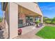 Picturesque covered patio with a ceiling fan, relaxing seating, and a lush green lawn, ideal for outdoor enjoyment at 93 E Santa Lucia Ln, Queen Creek, AZ 85140