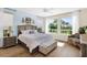 Sunlit bedroom with a king bed, hardwood floors, neutral tones, and large windows overlooking the yard at 93 E Santa Lucia Ln, Queen Creek, AZ 85140
