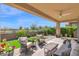 Inviting covered patio with comfortable seating, a ceiling fan, and views of the manicured backyard at 93 E Santa Lucia Ln, Queen Creek, AZ 85140