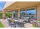Charming covered patio with outdoor seating, potted plants, and a view of the lush, landscaped backyard at 93 E Santa Lucia Ln, Queen Creek, AZ 85140