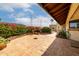 Inviting back patio with brick planters, colorful flowers, and lovely tile flooring at 9622 N 112Th Ave, Sun City, AZ 85351