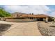 Beige home featuring a concrete driveway, desert landscaping, and a red tiled roof at 9622 N 112Th Ave, Sun City, AZ 85351