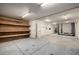 Wide garage with fluorescent lighting and wooden storage shelves at 9622 N 112Th Ave, Sun City, AZ 85351