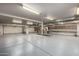 Massive garage with car lift access, ample storage, and workbench areas at 9622 N 112Th Ave, Sun City, AZ 85351