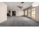 Bright living room featuring gray carpeting, ceiling fan, and french doors to the patio at 9622 N 112Th Ave, Sun City, AZ 85351