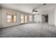 Spacious living room with gray carpeting, ceiling fan, and access to the patio at 9622 N 112Th Ave, Sun City, AZ 85351
