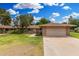 Charming single-story home with a well-maintained lawn, mature trees, and inviting curb appeal at 9805 W Gulf Hills Dr, Sun City, AZ 85351