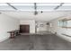 Spacious garage featuring concrete flooring, a workbench, and ample lighting at 9805 W Gulf Hills Dr, Sun City, AZ 85351