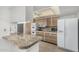 Bright kitchen featuring stone countertops, white appliances, and ample cabinet space at 9805 W Gulf Hills Dr, Sun City, AZ 85351