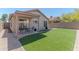 Home's backyard featuring a patio, table set, and a grassy lawn area at 17434 N 46Th Pl, Phoenix, AZ 85032