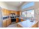 Bright kitchen featuring stainless steel appliances, light countertops, and natural wood cabinetry at 17434 N 46Th Pl, Phoenix, AZ 85032