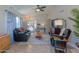 Spacious living room featuring a large black leather sofa, ceiling fan, and neutral walls at 17434 N 46Th Pl, Phoenix, AZ 85032
