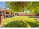 Expansive backyard with a manicured lawn, mature trees, and a cozy patio area at 10228 E Carol Ave, Mesa, AZ 85208
