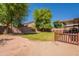 Spacious backyard features a lush green lawn and mature trees, offering privacy and shade at 10228 E Carol Ave, Mesa, AZ 85208