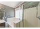Bright bathroom featuring a shower, bathtub, mosaic tile accents, and a large window, creating a relaxing space at 10228 E Carol Ave, Mesa, AZ 85208