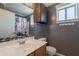 Bathroom with decorative mirror, wood cabinet, and patterned shower curtain at 10228 E Carol Ave, Mesa, AZ 85208