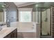 Bathroom featuring a tub, shower, and mosaic tile accents, creating a luxurious space at 10228 E Carol Ave, Mesa, AZ 85208