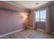 Bright bedroom with wood laminate flooring, window, and modern light fixture at 10228 E Carol Ave, Mesa, AZ 85208