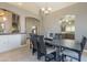 Dining room highlighting a dark wooden table, with kitchen and stair access at 10228 E Carol Ave, Mesa, AZ 85208